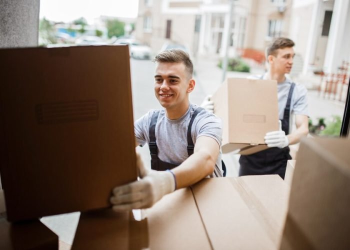two-movers-wearing-uniforms-are-unloading-van-full-boxes_472597-3662